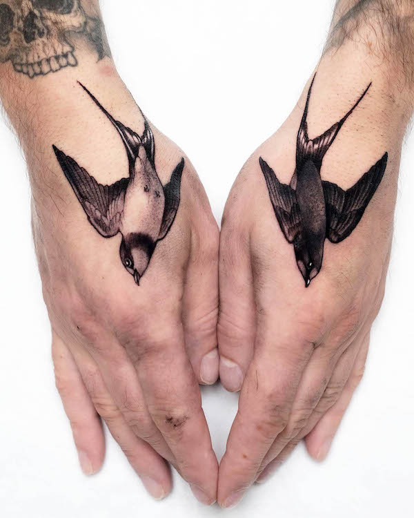 Black and white matching swallow hand tattoos by @danielflower