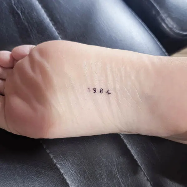 Birth of year foot tattoo by @crybabytattooer