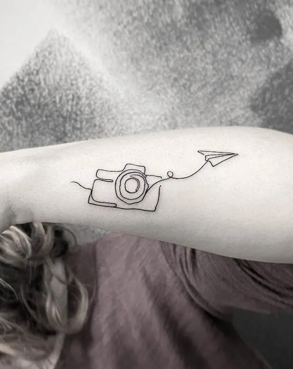 Camera and airplane outline tattoo by @j_erre_tattoo