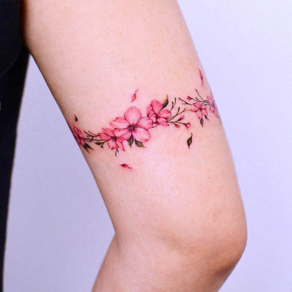 Cherry blossom wrap-around-the-arm tattoo by @yerae_tt