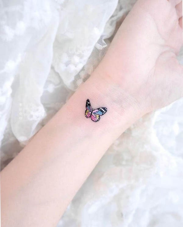 Colorful butterfly wrist tattoo by @dettolphin