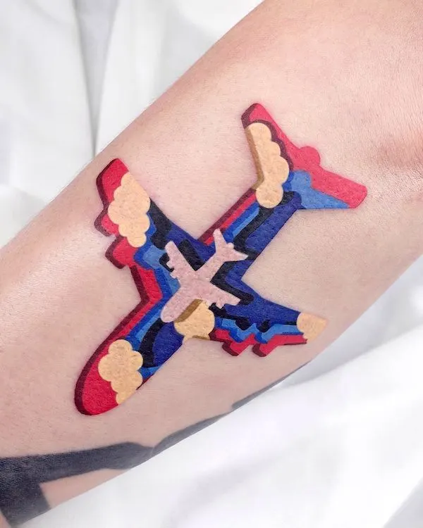 Colorful airplane cutout tattoo by @zoonmo