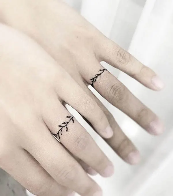 Dainty leaves wedding ring tattoos by @5e_tattoo