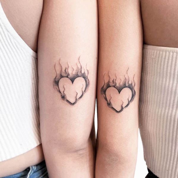 Fire heart matching tattoos by @uzotattoo