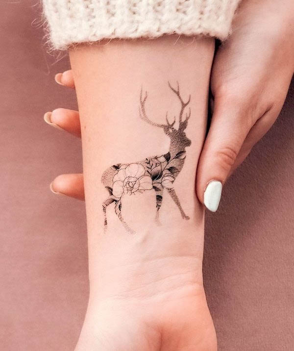 Floral deer wrist tattoo by @bunami.ink