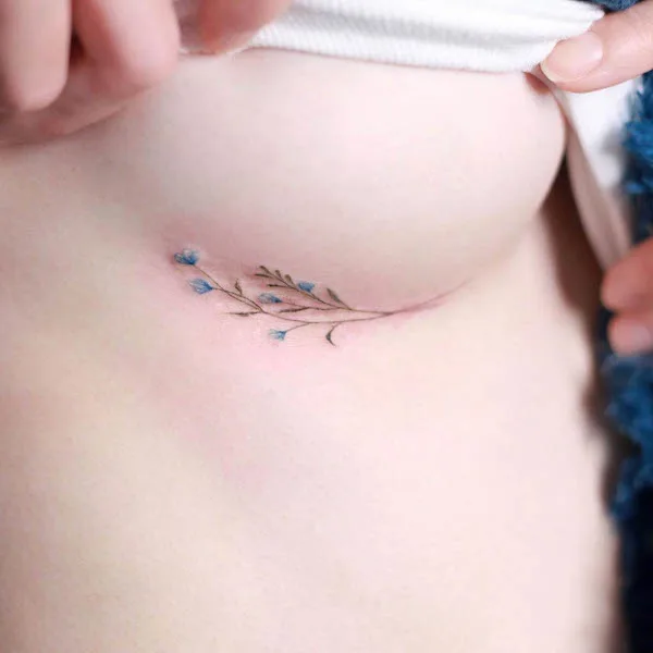 Flowers under boob tattoo by @tattooist_naro