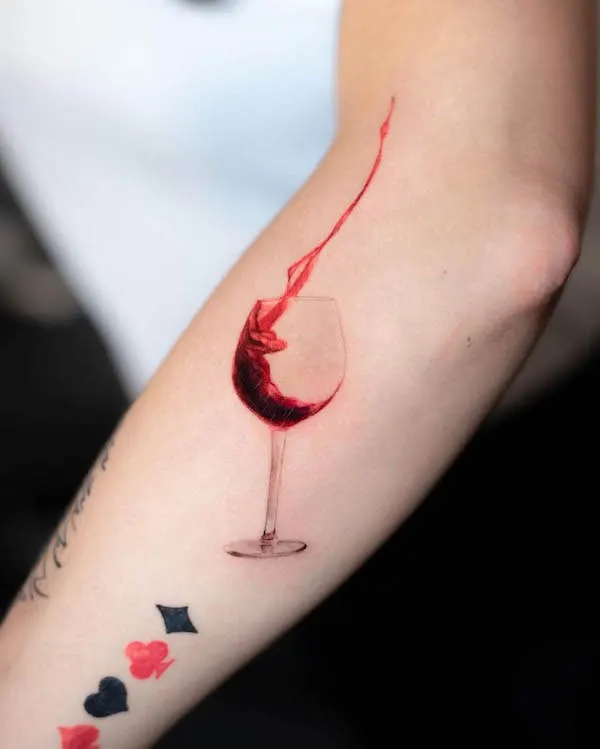 Glass of wine arm tattoo by @pelleossa_ink