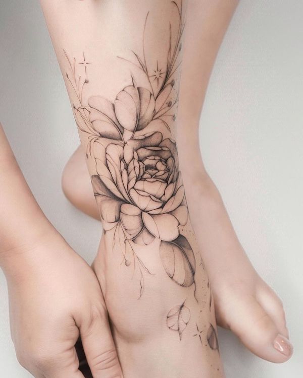 Greyscale flower foot tattoo by @lasstattoo