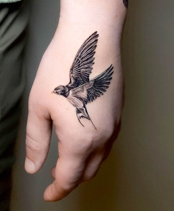 Hyper realistic swallow hand tattoo by @ivanruotolo.ink