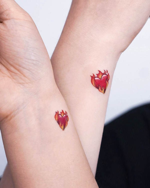 Matching burning heart tattoos by @stuffie.ink