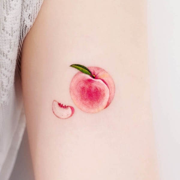 Peach upper arm tattoo by @e.ple_tattoo