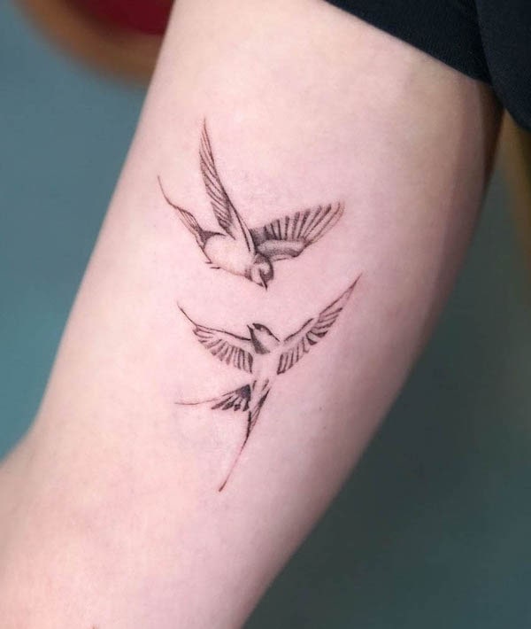 Simplistic swallow upper arm tattoo by @szyna.ink