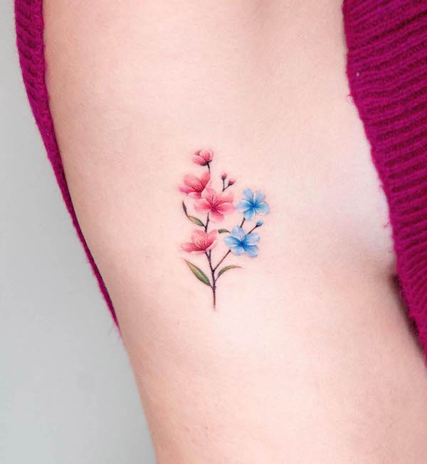 Small cherry blossom rib tattoo by @coy.tattoo