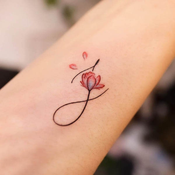 Small floral initial tattoo by @noul_tattoo