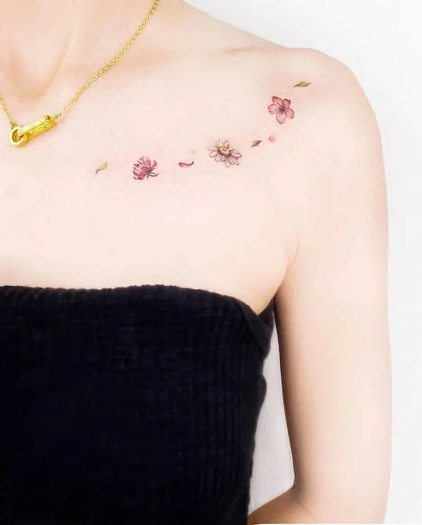 Small flowers chest tattoo by @miiu_tattoo