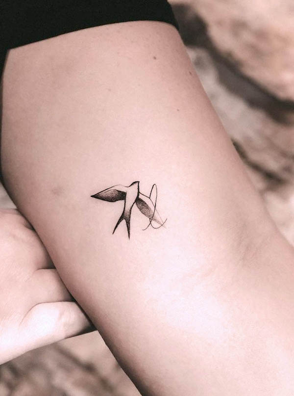 Small swallow and initial tattoo by @yoncaengel