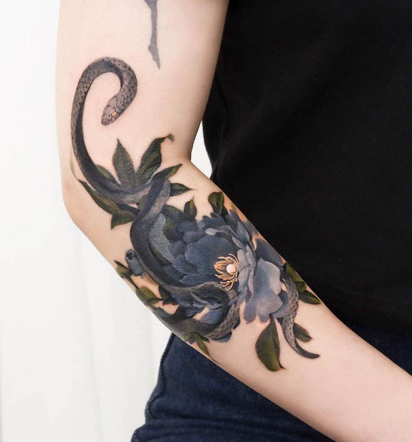 Snake and flowers elbow tattoo by @guppy.flowertattoo