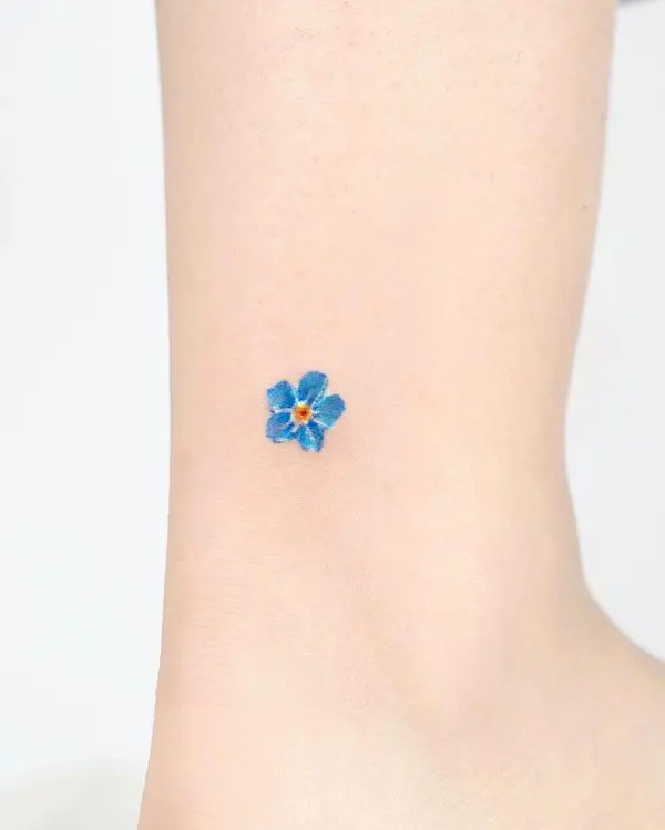 Tiny blue flower ankle tattoo by @tilda_tattoo