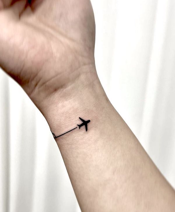 Tiny bracelet wrist airplane tattoo by @5e_tattoo