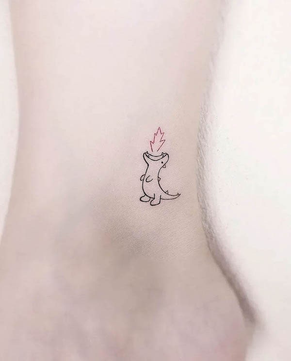 Tiny fire-breathing dinosaur ankle tattoo by @gorae_tattoo