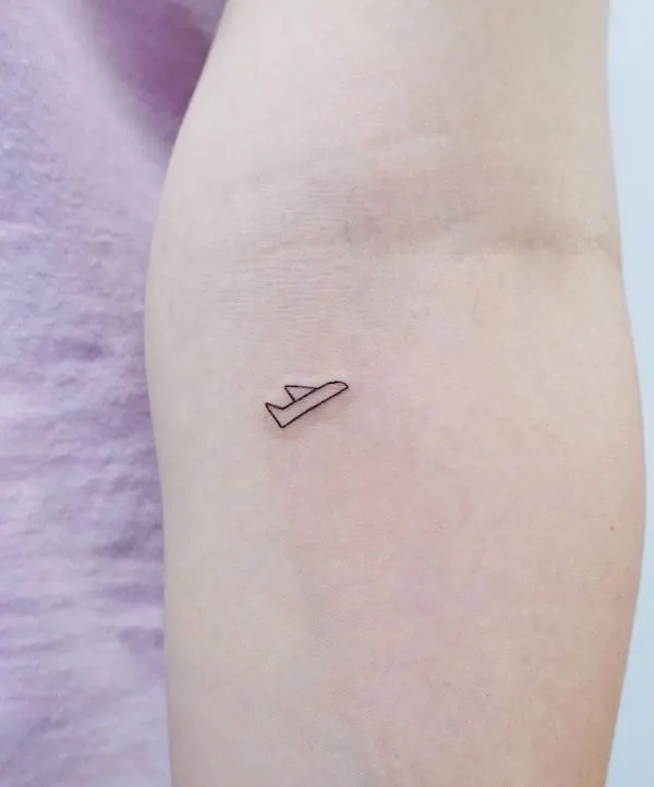 Tiny minimalist plane tattoo by @simbar_tattoo