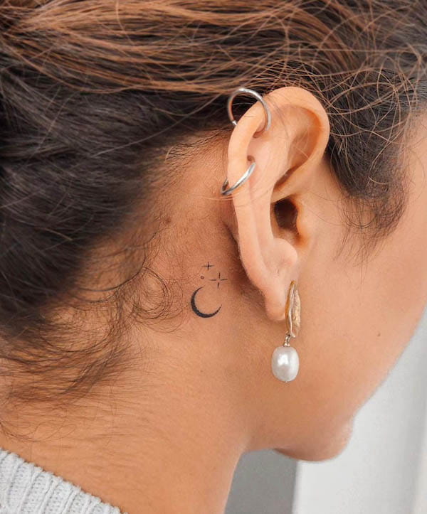 Tiny moon and stars behind the ear by @helentattootx