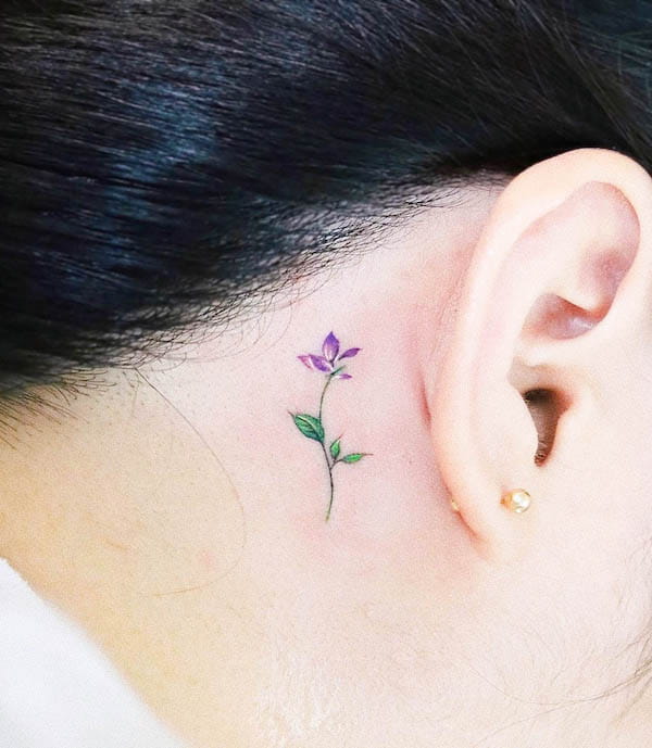 Tiny violet behind-the-ear tattoo by @vane.tattoo_