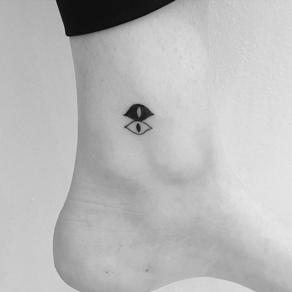 Tiny yin yang eye tattoo on the ankle by @doetanitattoer