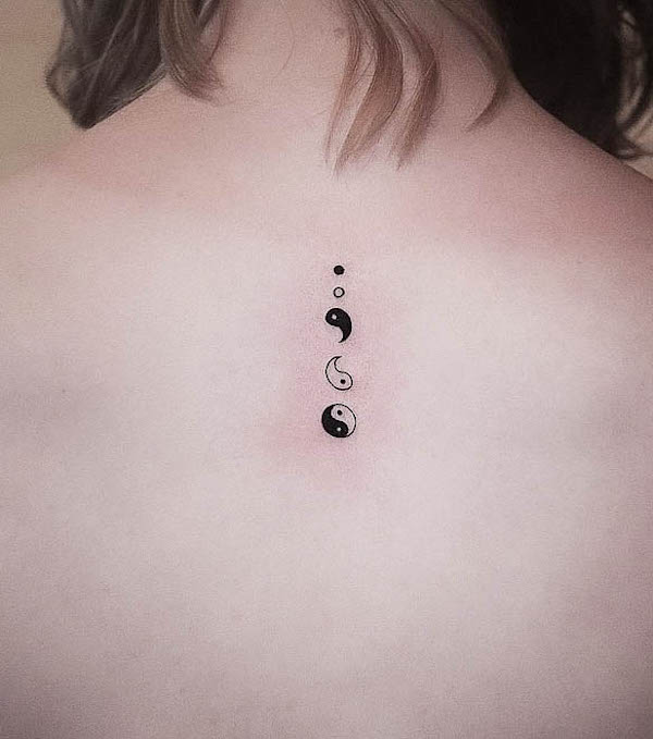 Tiny yin yang symbols back tattoo by @chad_bolo