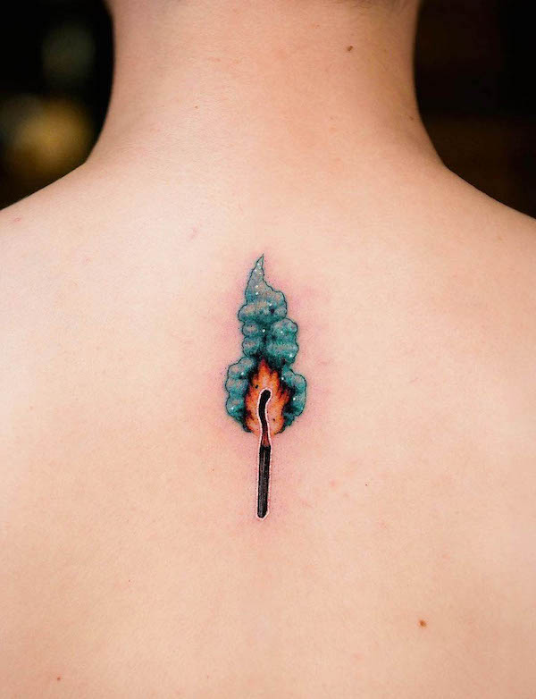 Whimsical matchstick on fire back tattoo by @evgenymel