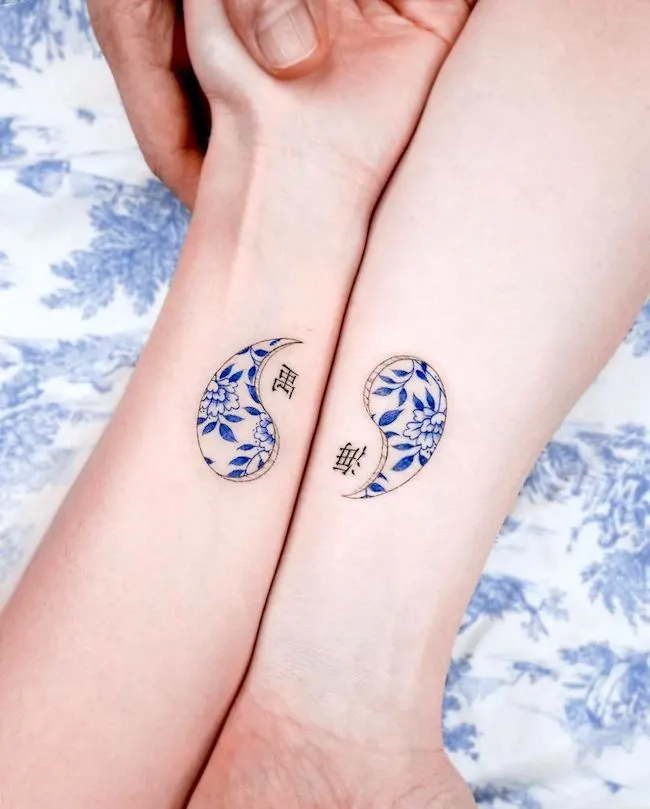 Yin and yang matching wrist tattoos by @e.nal_.tattoo