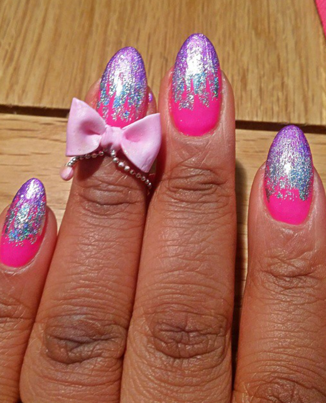 bright pink and glitter blue and purple nails with bow charms