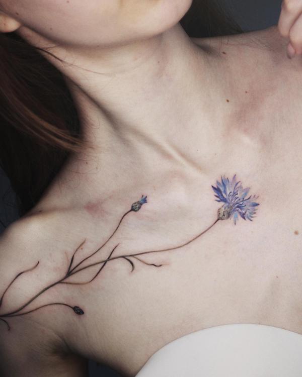 Single cornflower aboveboob tattoo
